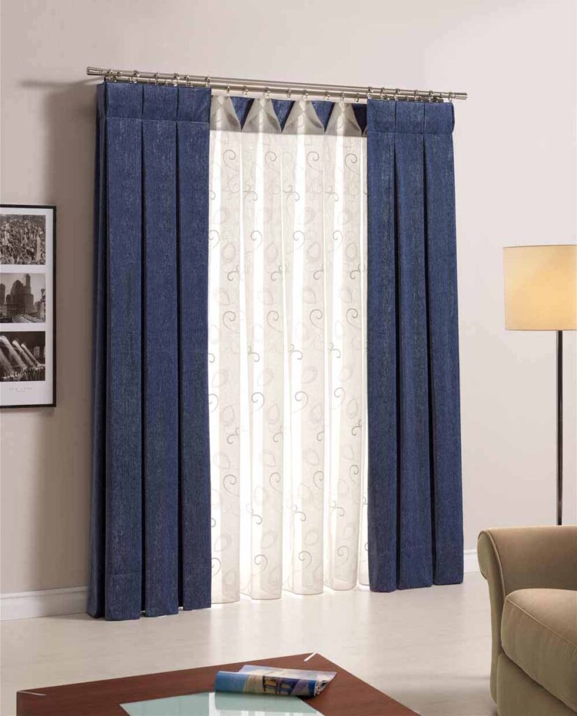 VENTANA DECORADA CON CORTINAS Y CAIDAS LATERALES EN BARRA DOBLE, EN TONOS AZULES